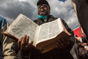 Pastor Vernon Williams holds a bible that survived the explosion at the Spanish Christian Church in Harlem